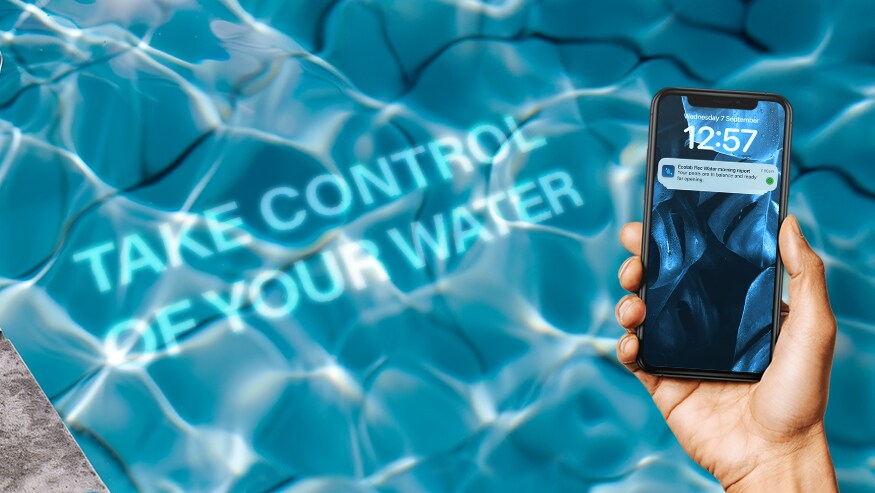 A hand holding a smartphone displaying a notification. In the background, there is an image of a swimming pool water with text overlaying it that reads take control of your water.
